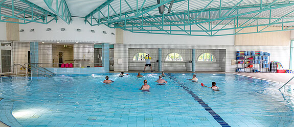 Wassergymnastik Ein Therapeut leitet eine Wassergymnastik-Gruppe an.