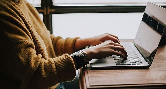 Frau schreibt am Laptop