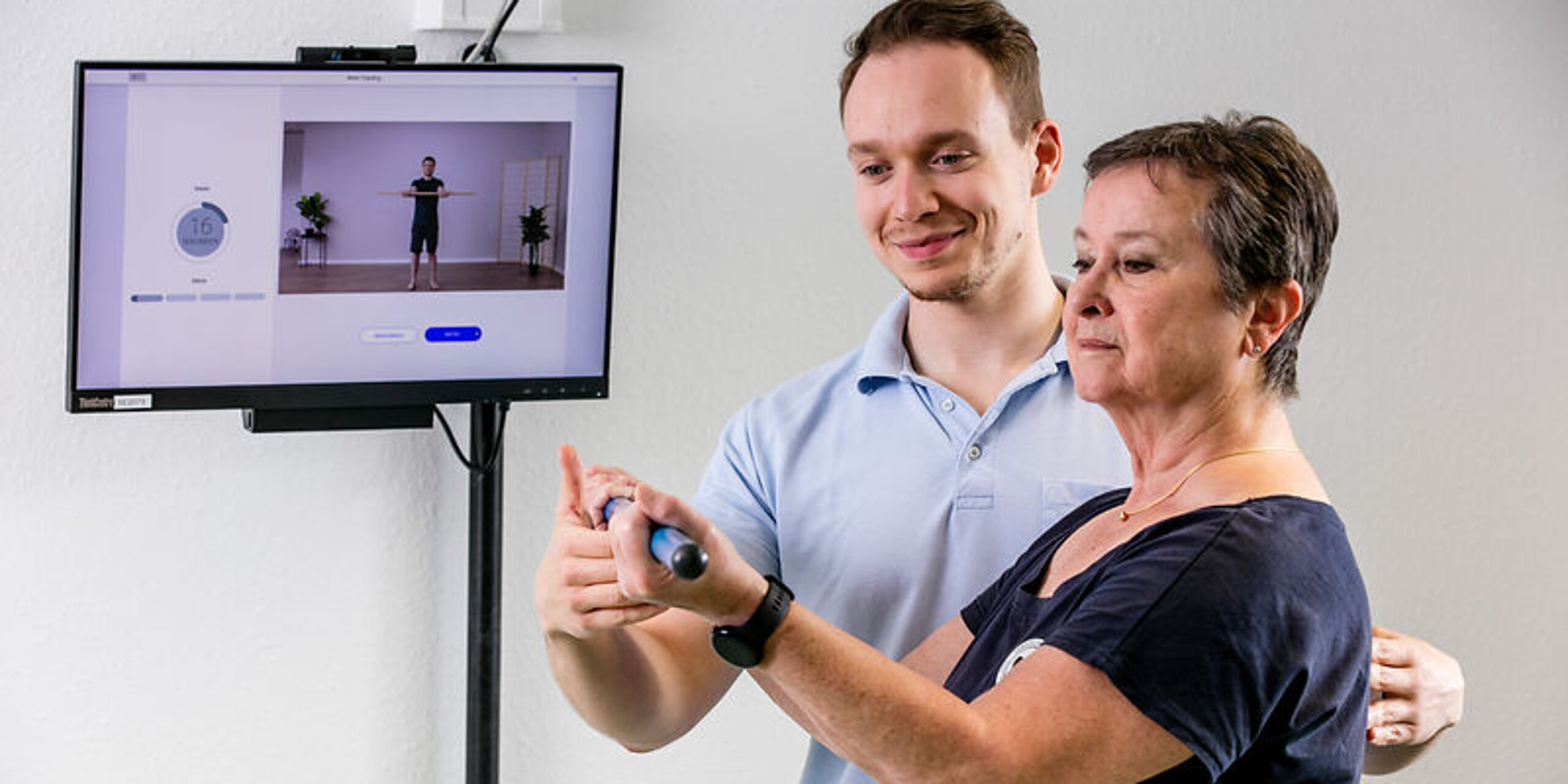 Ein Therapeut weist eine Patientin in die digitale Nachsorge ein