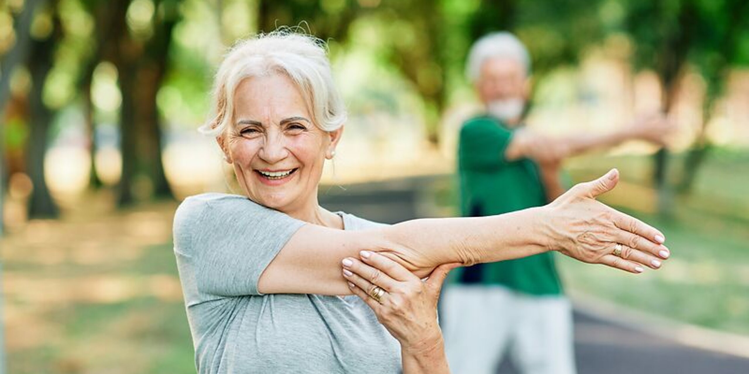 Patientin Gymnastik im Park Frau macht Dehnübungen im Park.