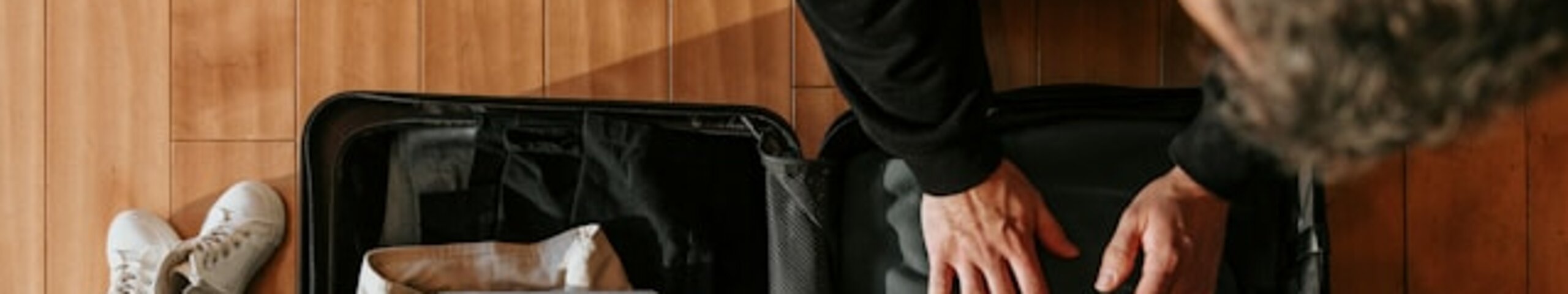 Eine Person packt einen Koffer.